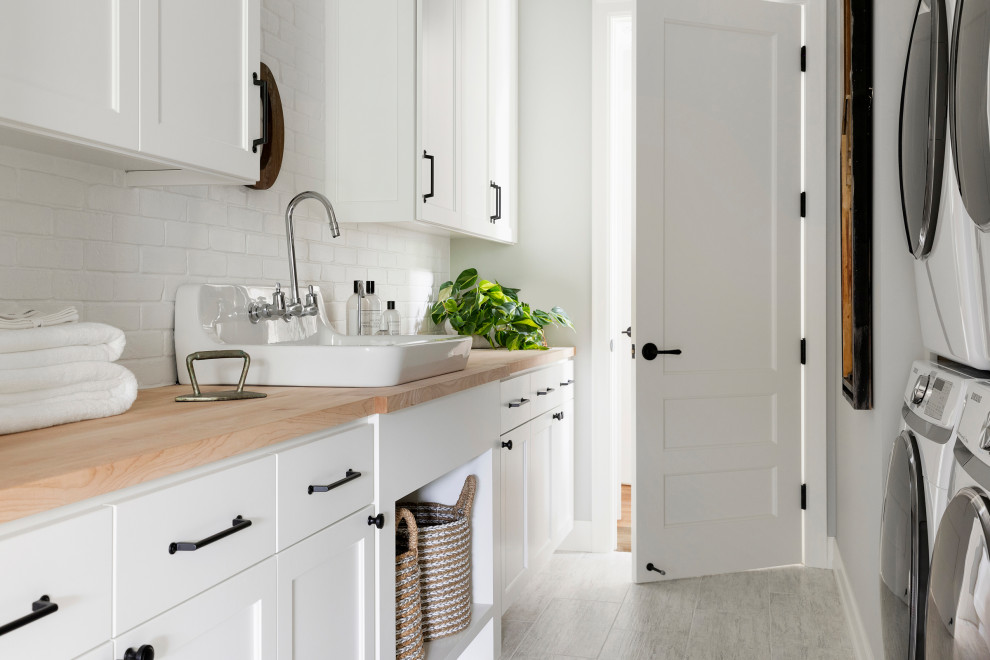 Zweizeilige, Mittelgroße Klassische Waschküche mit Landhausspüle, weißen Schränken, Arbeitsplatte aus Holz, grauer Wandfarbe und Waschmaschine und Trockner nebeneinander in Minneapolis