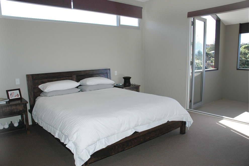 Inspiration for a large contemporary master bedroom in Sydney with beige walls and carpet.