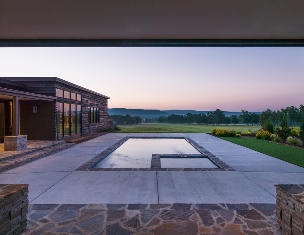 Trendy backyard stone and rectangular hot tub photo