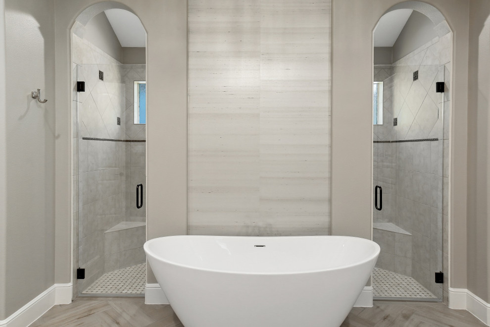 This is an example of a large transitional master wet room bathroom in Houston with raised-panel cabinets, white cabinets, a freestanding tub, beige tile, ceramic tile, grey walls, ceramic floors, an undermount sink, engineered quartz benchtops, grey floor, a hinged shower door, white benchtops, a double vanity, a built-in vanity, vaulted and wallpaper.