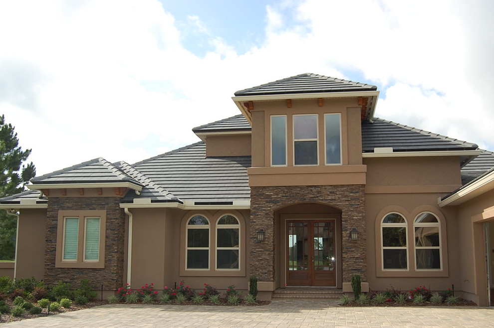 This is an example of a contemporary two-storey stucco brown exterior in Jacksonville with a hip roof.