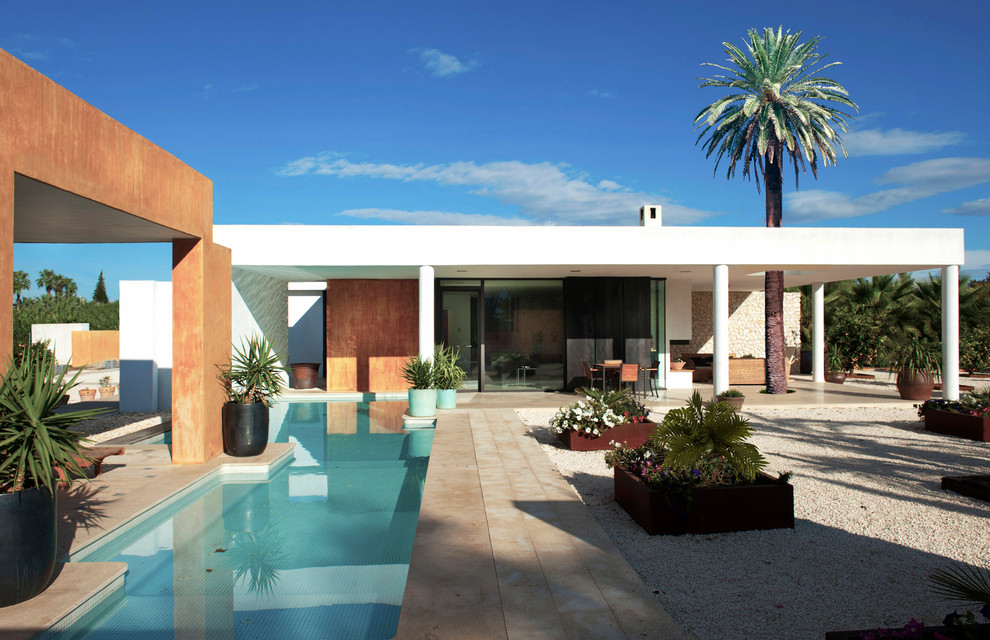 Design ideas for a mediterranean backyard custom-shaped lap pool in Madrid.
