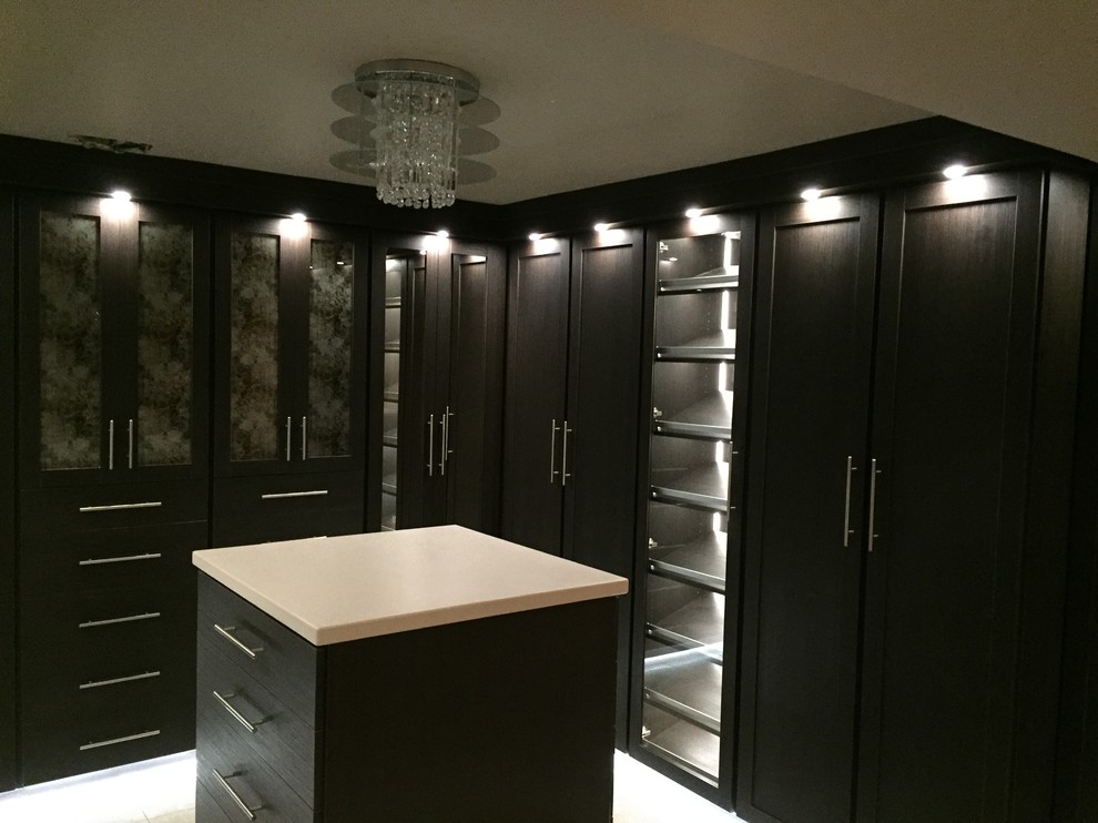 This is an example of a large contemporary gender-neutral walk-in wardrobe in Seattle with raised-panel cabinets and brown cabinets.