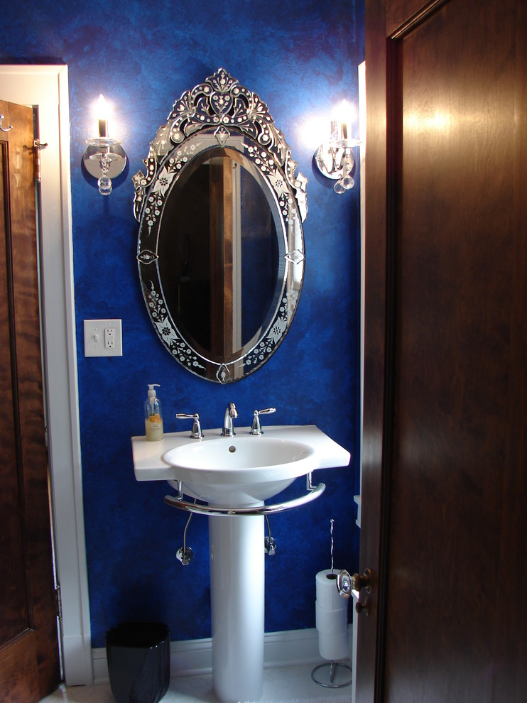 This is an example of a small traditional bathroom in Cleveland with a pedestal sink, an alcove tub, white tile, porcelain tile, blue walls and porcelain floors.
