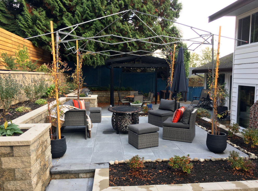 Photo of a medium sized contemporary back patio in Vancouver with concrete paving and a fireplace.