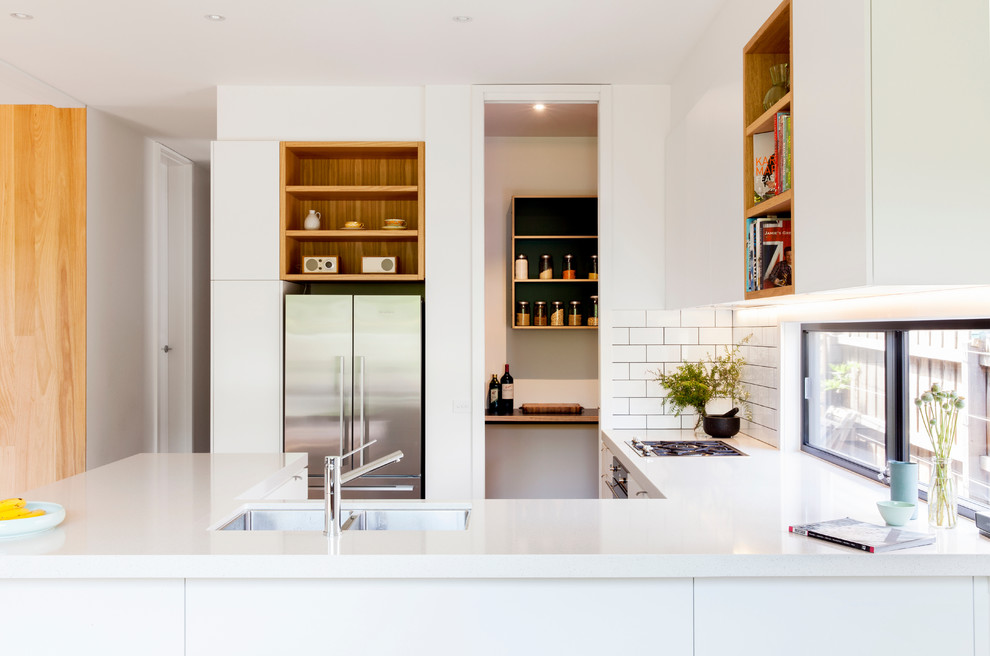 Photo of a contemporary kitchen in Melbourne with stainless steel appliances, no island and white cabinets.