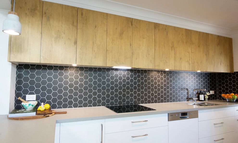 Photo of a mid-sized modern galley eat-in kitchen in Melbourne with an undermount sink, flat-panel cabinets, white cabinets, quartz benchtops, grey splashback, mosaic tile splashback, panelled appliances, light hardwood floors and no island.