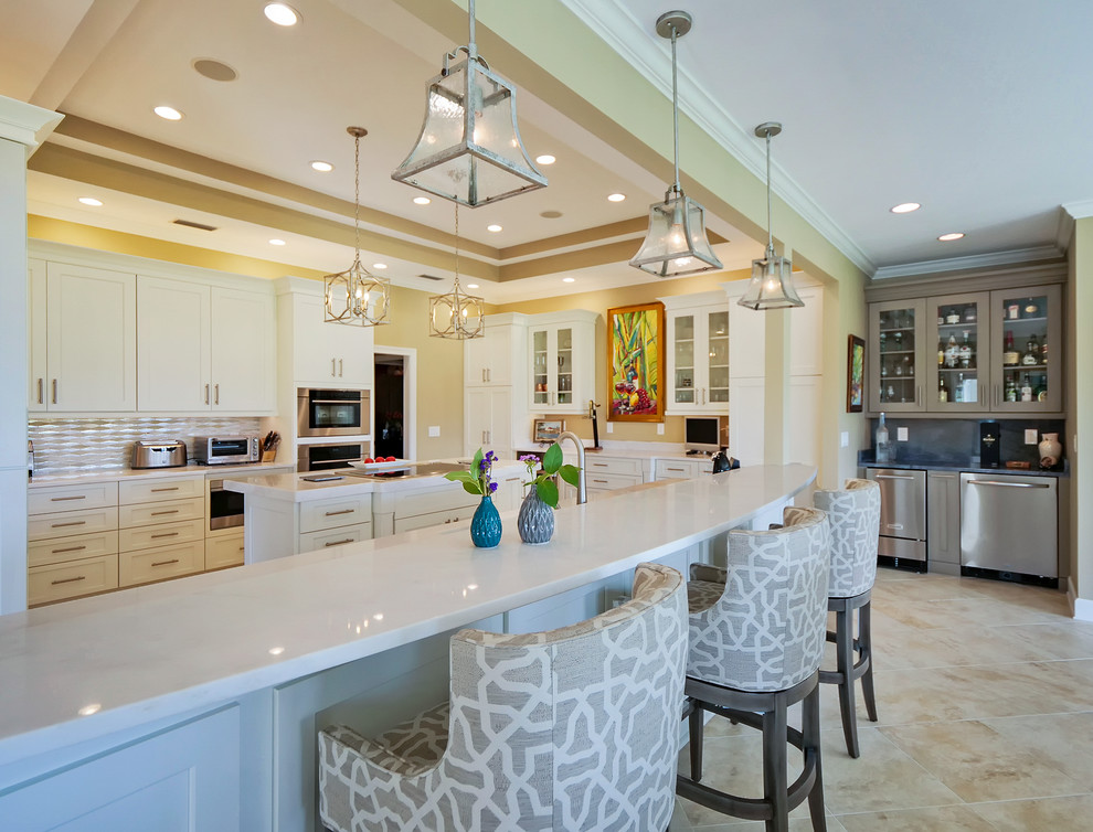 Expansive tropical u-shaped eat-in kitchen in Jacksonville with an undermount sink, beaded inset cabinets, white cabinets, quartzite benchtops, beige splashback, marble splashback, stainless steel appliances, porcelain floors, multiple islands, beige floor and white benchtop.