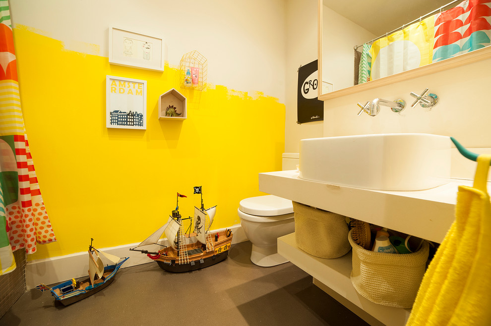 This is an example of a mid-sized eclectic powder room in Other with open cabinets, white cabinets, a two-piece toilet, multi-coloured walls and a vessel sink.
