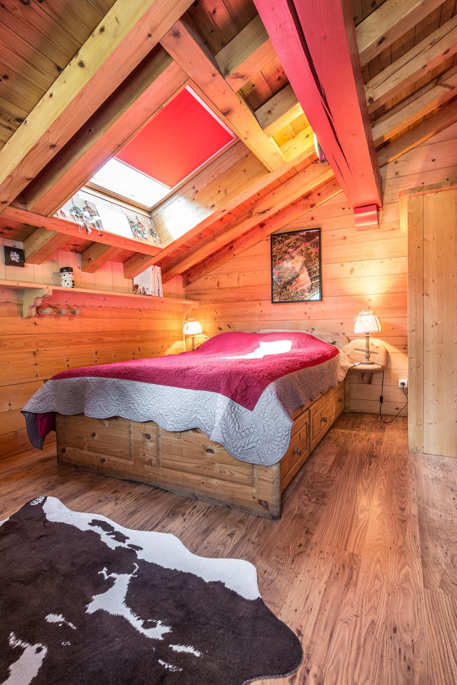 Example of a mid-sized mountain style medium tone wood floor, brown floor, wood ceiling and wood wall bedroom design in Other with beige walls
