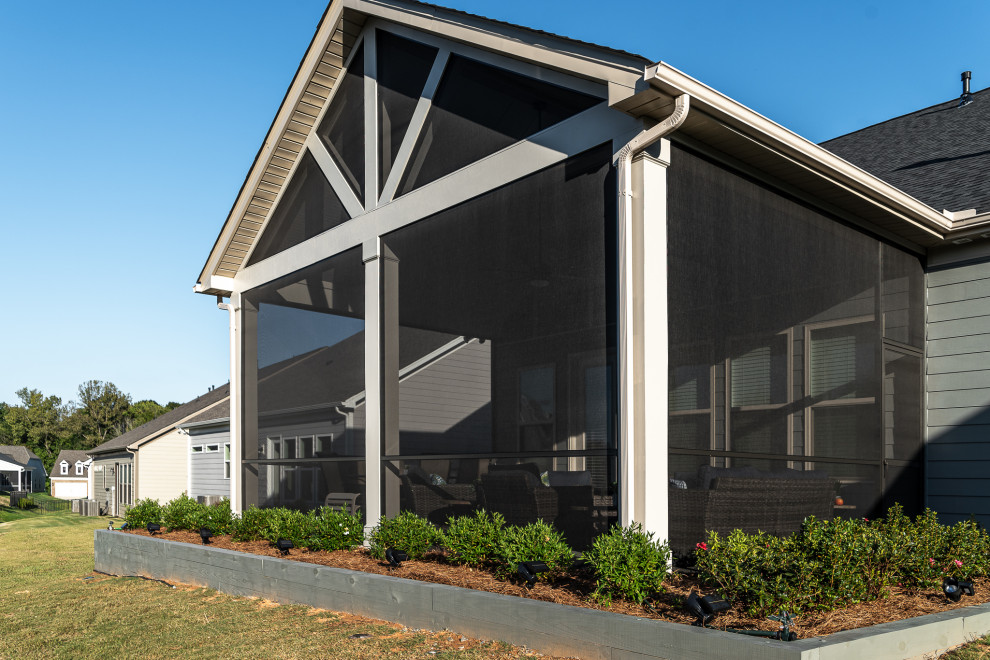 Große, Verglaste, Überdachte Moderne Veranda hinter dem Haus mit Betonplatten und Stahlgeländer in Charlotte