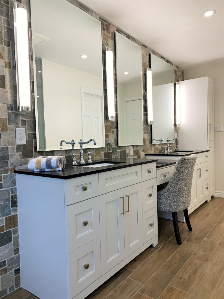Inspiration for a mid-sized transitional master bathroom in Toronto with shaker cabinets, white cabinets, a freestanding tub, a one-piece toilet, slate, porcelain floors, quartzite benchtops, beige floor, black benchtops, a shower seat, a double vanity and a freestanding vanity.