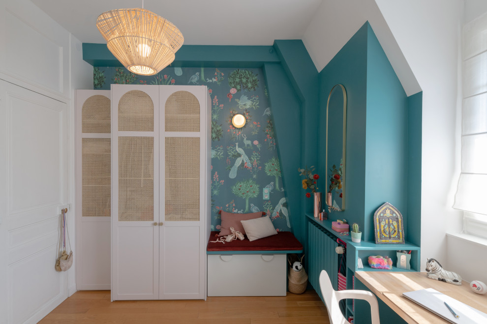 Exemple d'une chambre d'enfant éclectique de taille moyenne avec un mur bleu, parquet clair, un sol marron, un plafond voûté et du papier peint.