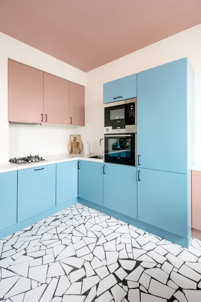 Design ideas for a contemporary l-shaped open plan kitchen in Moscow with an undermount sink, flat-panel cabinets, blue cabinets, white splashback, stainless steel appliances, no island, multi-coloured floor and white benchtop.