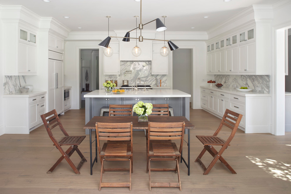 This is an example of a transitional kitchen/dining combo in San Francisco with white walls and light hardwood floors.