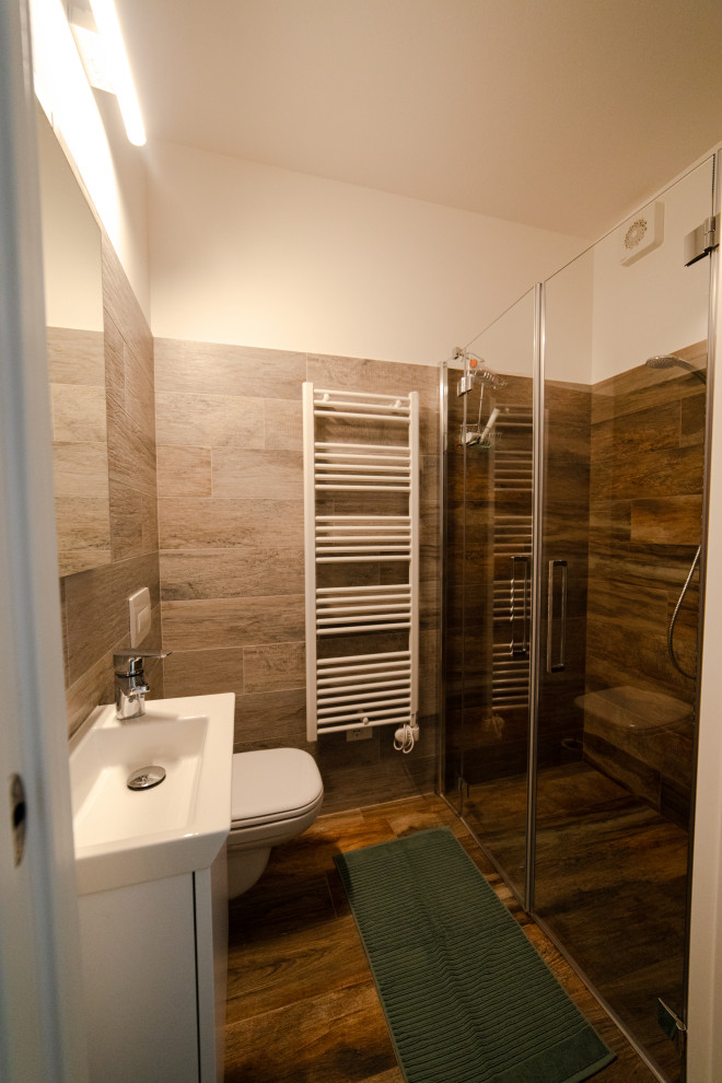 Photo of a medium sized scandinavian cloakroom in Milan with flat-panel cabinets, white cabinets, a one-piece toilet, brown tiles, wood-effect tiles, brown walls, wood-effect flooring, brown floors, a floating vanity unit, a console sink, quartz worktops and white worktops.