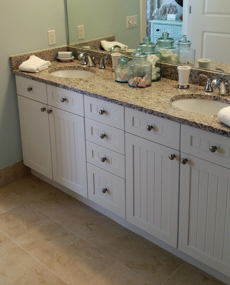 This is an example of a mid-sized beach style master bathroom in Other with recessed-panel cabinets, white cabinets, marble benchtops and marble floors.
