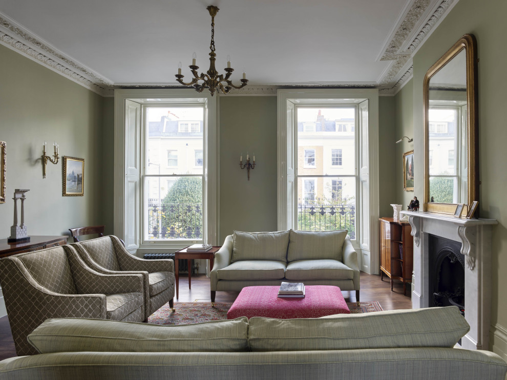 Photo of a classic living room in London with grey walls, a standard fireplace and brown floors.