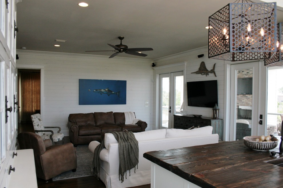 Beach style open concept living room in Other with dark hardwood floors and a wall-mounted tv.