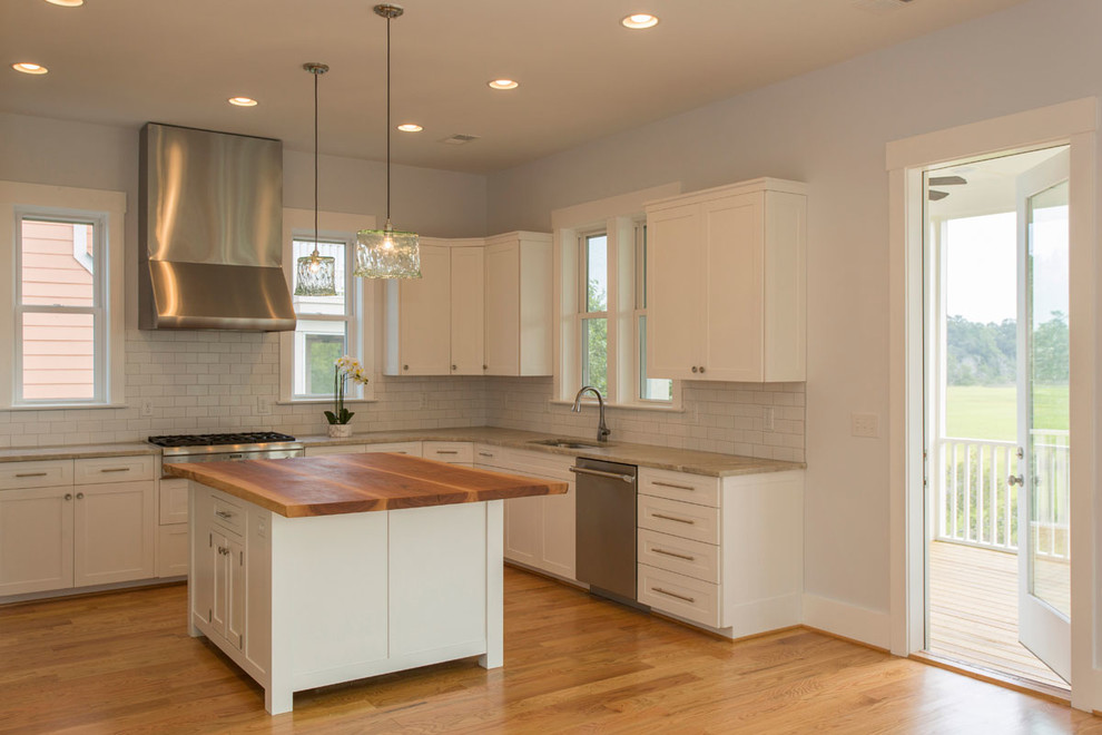 Eat-in kitchen - large transitional u-shaped light wood floor eat-in kitchen idea in Charleston with an undermount sink, shaker cabinets, white cabinets, quartz countertops, white backsplash, subway tile backsplash, stainless steel appliances and an island