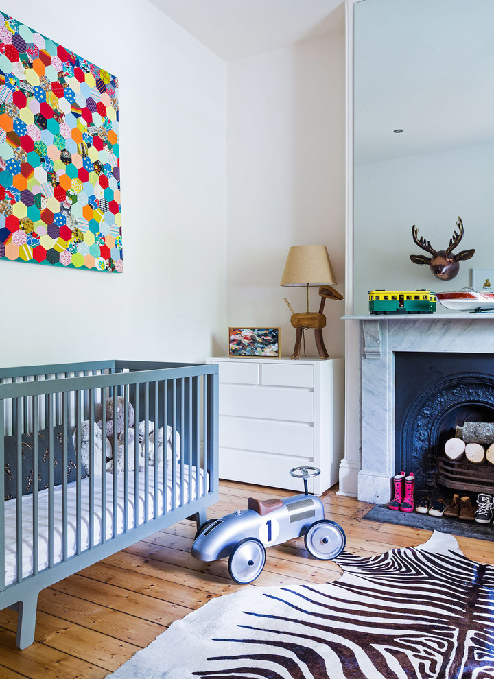 Photo of an eclectic nursery for boys in Melbourne with light hardwood floors and white walls.