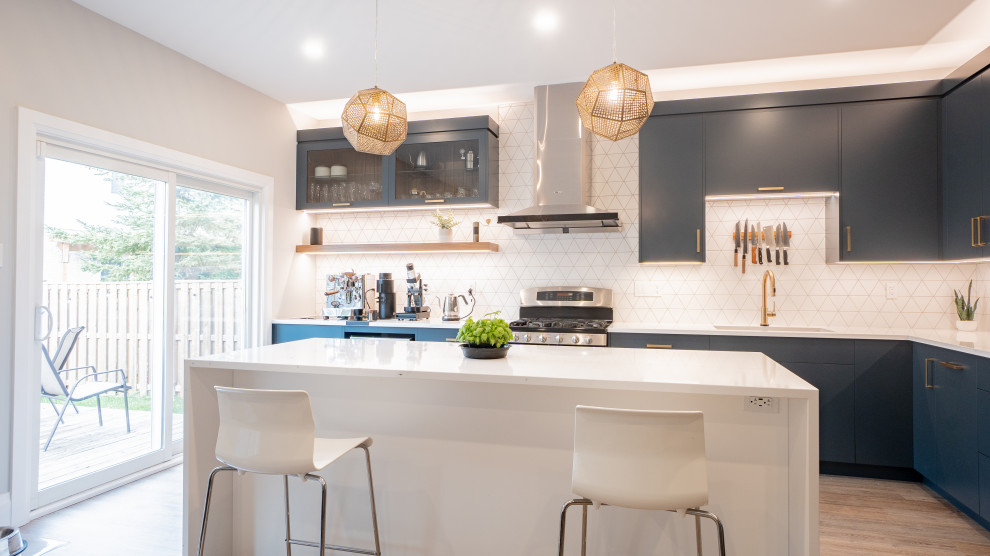 Inspiration for a modern l-shaped vinyl floor and beige floor open concept kitchen remodel in Toronto with flat-panel cabinets, blue cabinets, quartz countertops, white backsplash, cement tile backsplash, stainless steel appliances, an island and white countertops