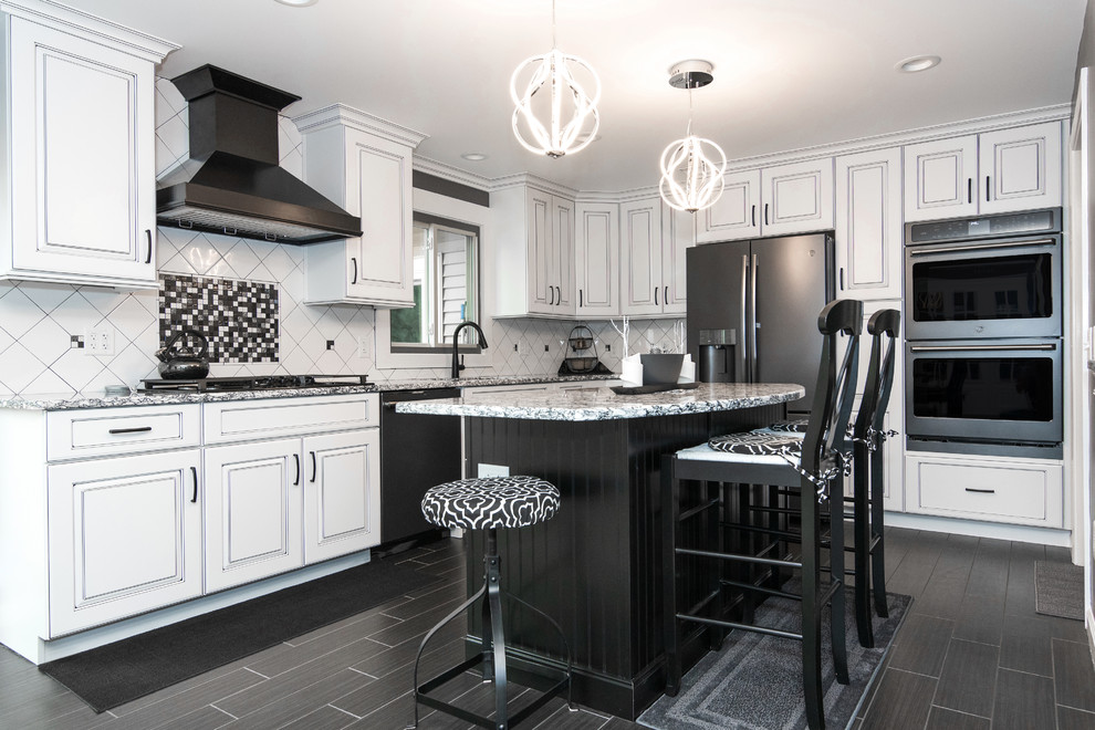 Inspiration for a large modern l-shaped eat-in kitchen in Bridgeport with an undermount sink, raised-panel cabinets, white cabinets, white splashback, ceramic splashback, black appliances, porcelain floors, with island, black floor and multi-coloured benchtop.