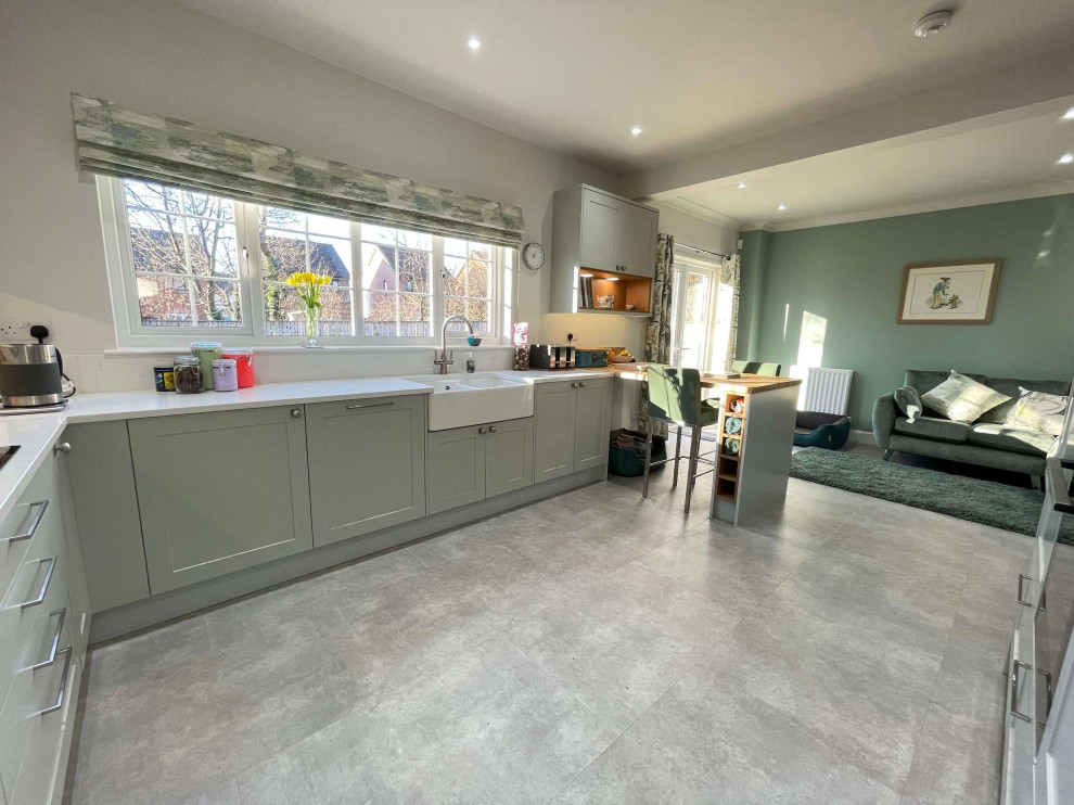 Inspiration for a medium sized classic u-shaped open plan kitchen with shaker cabinets, grey cabinets, quartz worktops, a breakfast bar, grey floors and white worktops.