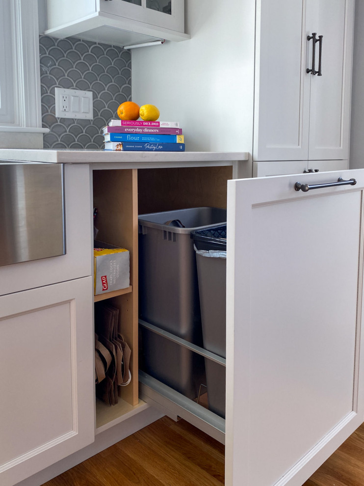 Aménagement d'une cuisine classique en L avec un évier de ferme, un placard à porte shaker, des portes de placard violettes, un plan de travail en quartz modifié, une crédence grise, une crédence en céramique, un électroménager en acier inoxydable, parquet clair, îlot et un plan de travail blanc.