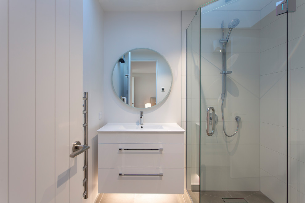 Small modern master bathroom in Other with raised-panel cabinets, a corner shower, a one-piece toilet, white tile, ceramic floors and a hinged shower door.