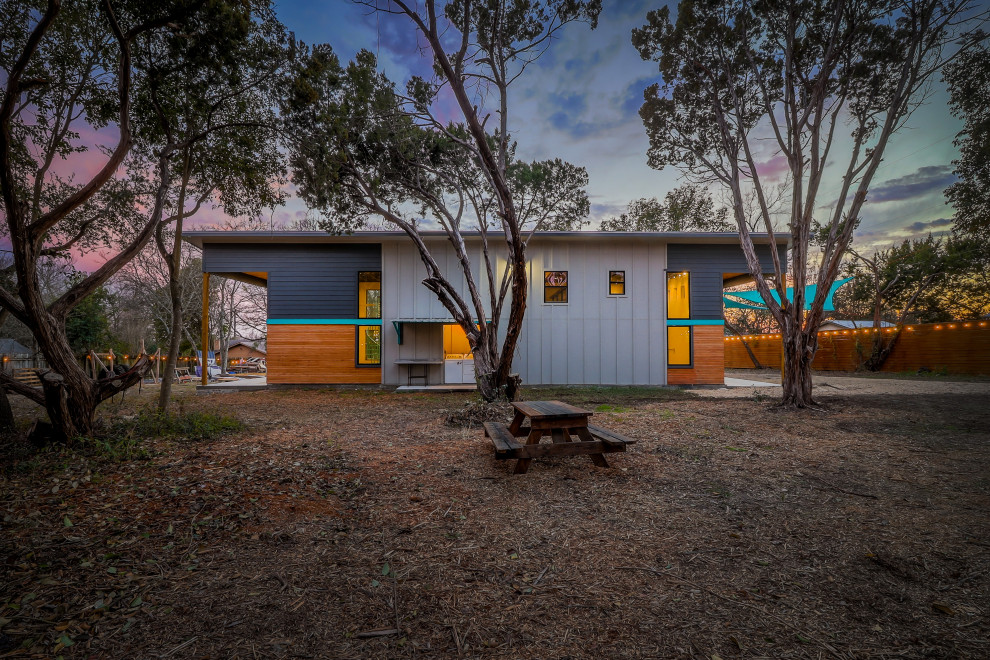 Kleines, Zweistöckiges Eklektisches Tiny House mit Mix-Fassade, blauer Fassadenfarbe, Pultdach, Blechdach, grauem Dach und Wandpaneelen in Austin