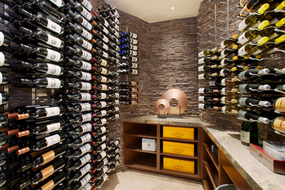 This is an example of a small contemporary wine cellar in Other with travertine floors, storage racks and beige floor.