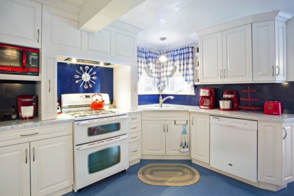 Eat-in kitchen - transitional l-shaped blue floor eat-in kitchen idea in Boston with raised-panel cabinets, white cabinets, blue backsplash, white appliances, an island and white countertops