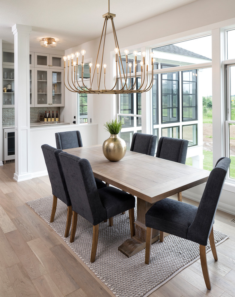 Transitional dining room in Minneapolis with white walls, light hardwood floors and beige floor.
