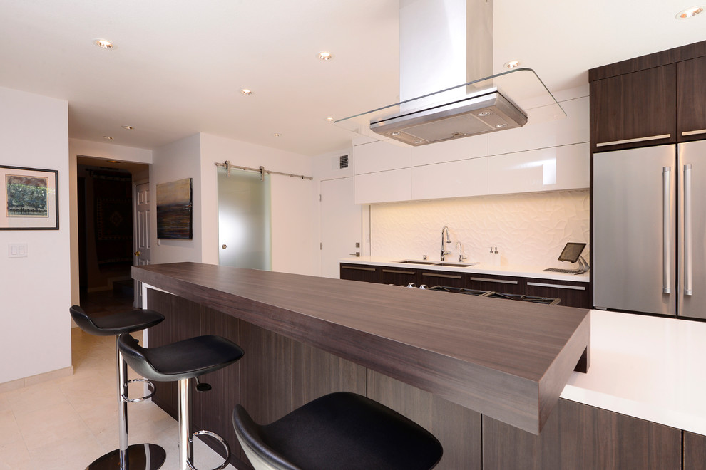 Mid-sized modern galley eat-in kitchen in Orange County with an undermount sink, flat-panel cabinets, dark wood cabinets, quartz benchtops, white splashback, ceramic splashback, stainless steel appliances, porcelain floors and with island.