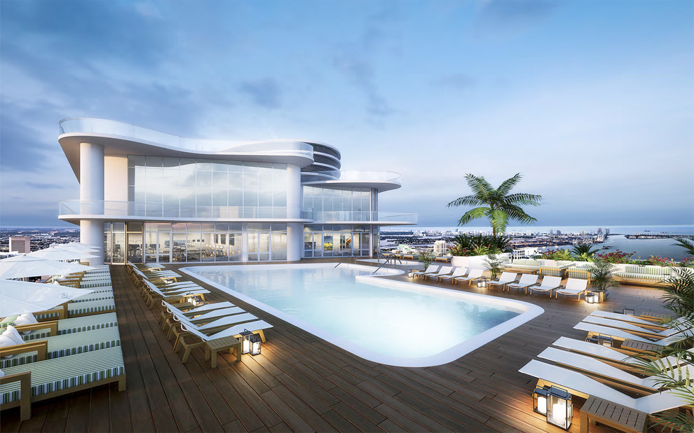 Inspiration for a mid-sized modern rooftop l-shaped lap pool in Miami with decking.