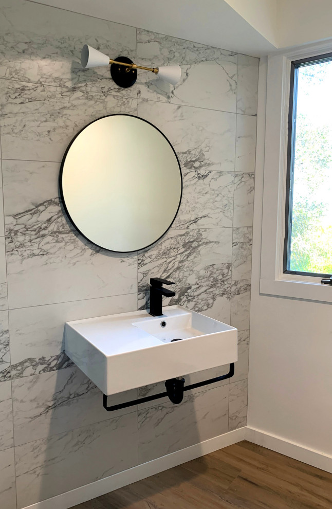 Modern inredning av ett litet badrum med dusch, med en hörndusch, grå kakel, vita väggar, travertin golv och ett väggmonterat handfat