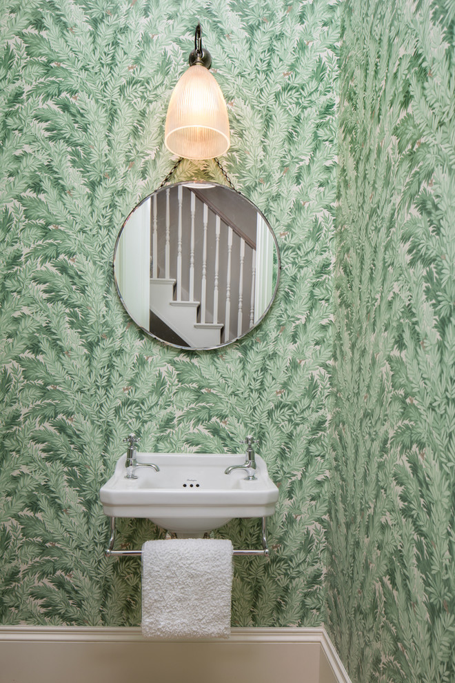 Photo of a mid-sized traditional powder room in London with orange walls and a wall-mount sink.