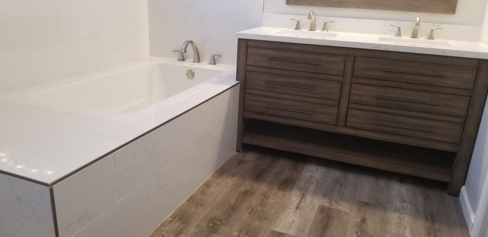 Photo of a mid-sized contemporary master bathroom in Los Angeles with flat-panel cabinets, brown cabinets, a japanese tub, a corner shower, a two-piece toilet, white tile, porcelain tile, grey walls, vinyl floors, an undermount sink, quartzite benchtops, grey floor, a hinged shower door, white benchtops, a double vanity and a freestanding vanity.