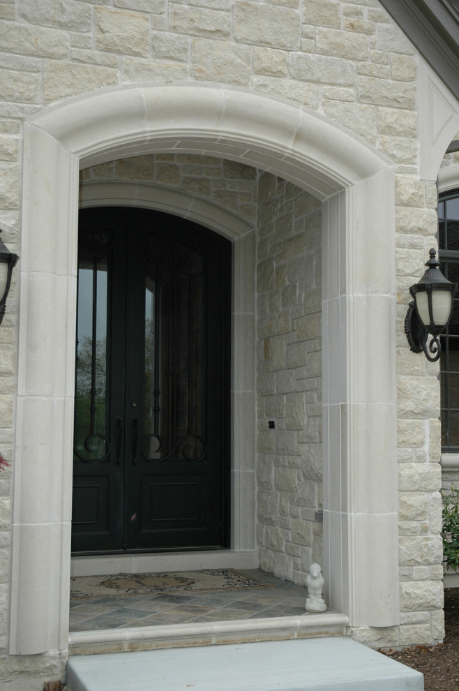 Traditional beige house exterior with stone veneer.