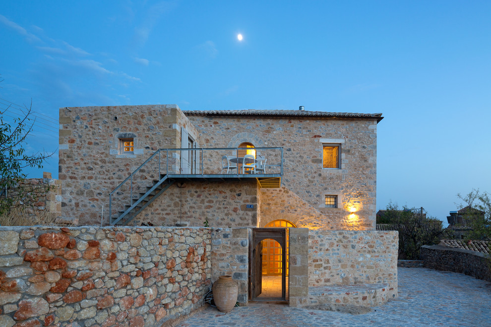 This is an example of a mediterranean exterior in Other with stone veneer.