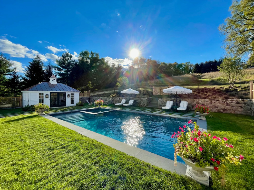 Foto di una grande piscina naturale tradizionale rettangolare dietro casa con una dépendance a bordo piscina e pavimentazioni in pietra naturale