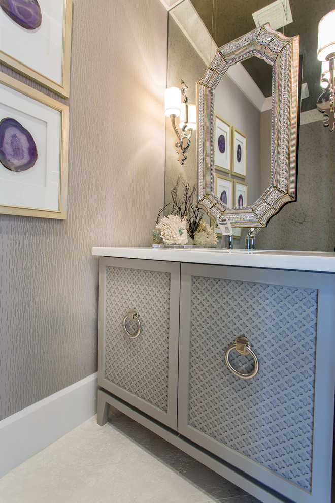 This is an example of a small transitional powder room in Miami with beaded inset cabinets, white cabinets, marble benchtops and travertine floors.