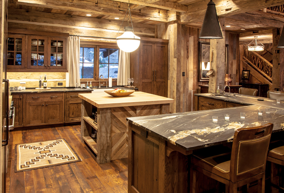 Large country kitchen in Boston with a farmhouse sink, glass-front cabinets, dark wood cabinets, timber splashback, dark hardwood floors and with island.