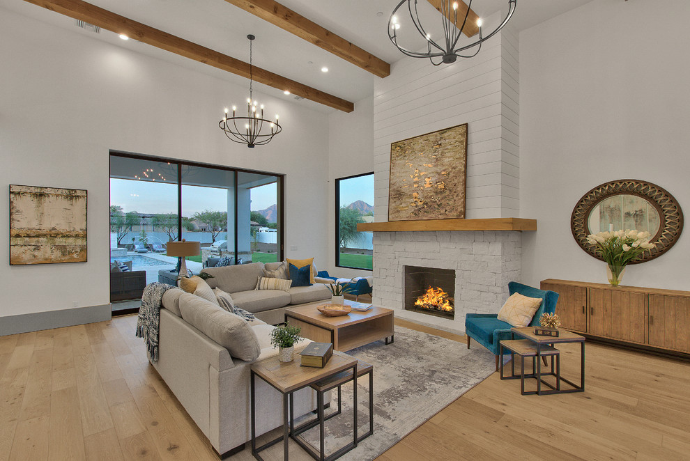 Country open concept living room in Phoenix with white walls, light hardwood floors, a standard fireplace, a stone fireplace surround and beige floor.