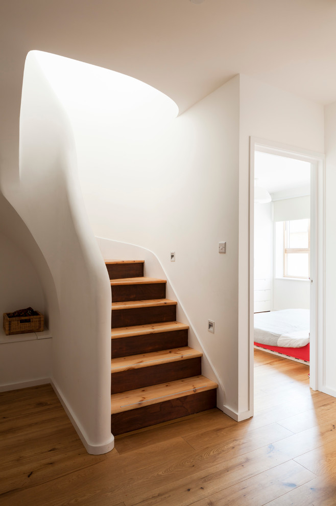 Design ideas for a mid-sized contemporary wood u-shaped staircase in London with wood risers.