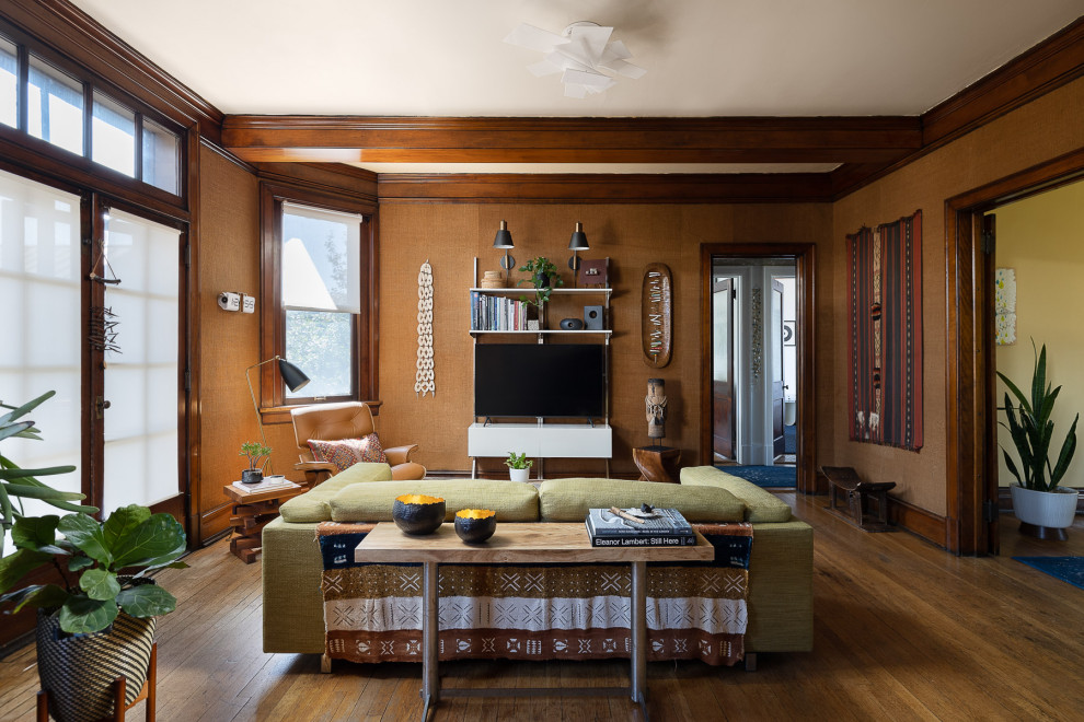 Exemple d'un grand salon chic fermé avec un mur marron, un téléviseur indépendant, un sol marron, du papier peint, un sol en bois brun et poutres apparentes.