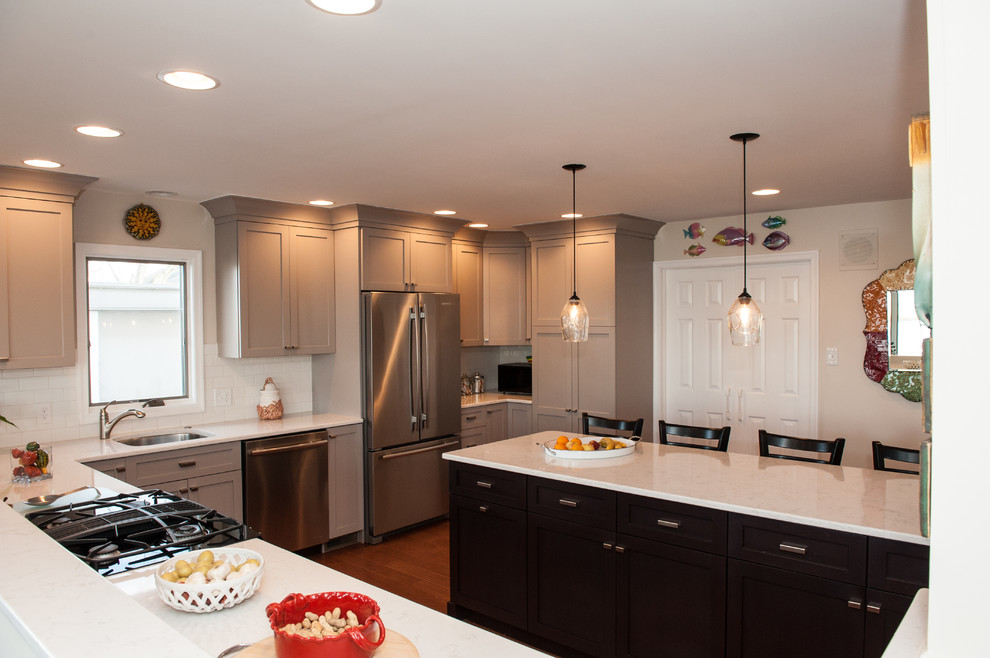 Eat-in kitchen - large transitional l-shaped dark wood floor and brown floor eat-in kitchen idea in Philadelphia with an undermount sink, shaker cabinets, white cabinets, quartz countertops, white backsplash, subway tile backsplash, stainless steel appliances and a peninsula