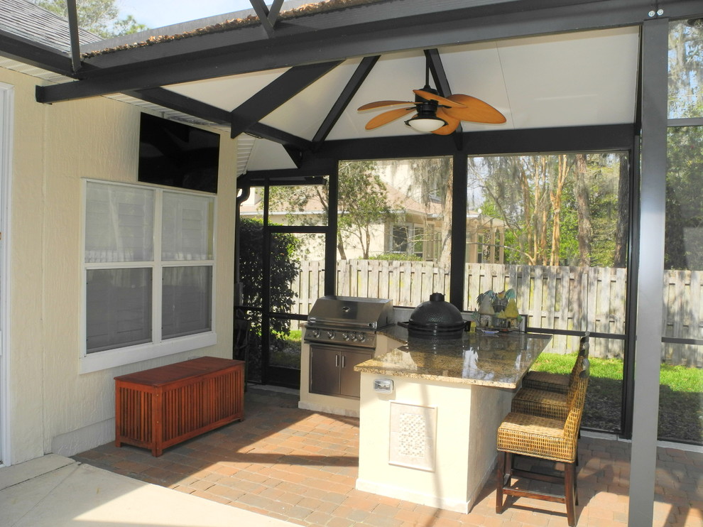 Mid-sized transitional backyard patio in Jacksonville with an outdoor kitchen, concrete pavers and an awning.