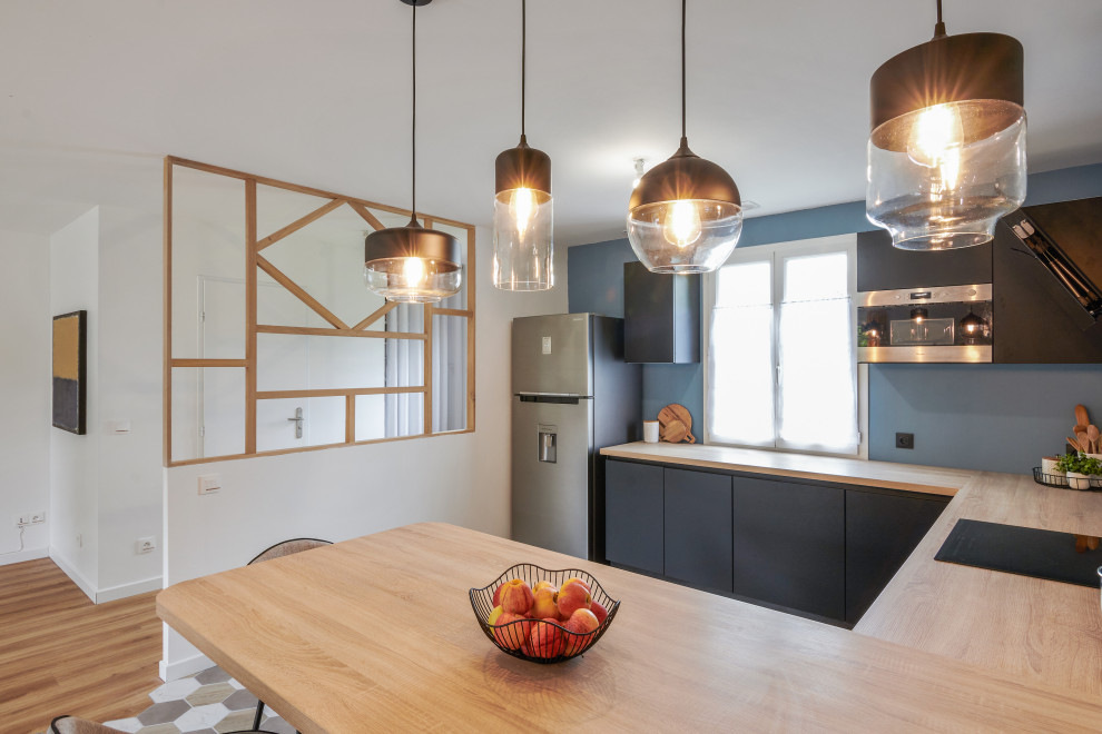 Inspiration for a medium sized modern u-shaped open plan kitchen in Le Havre with flat-panel cabinets, black cabinets, wood worktops, integrated appliances, ceramic flooring, a breakfast bar, multi-coloured floors and beige worktops.